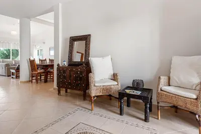 a living room with chairs and a mirror and a table at Villa Thea, Luxury Cliff Sea View in Pissouri