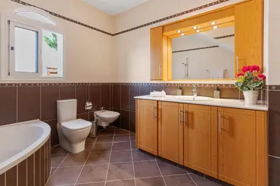 a bathroom with a sink toilet and a mirror at Villa Thea, Luxury Cliff Sea View in Pissouri