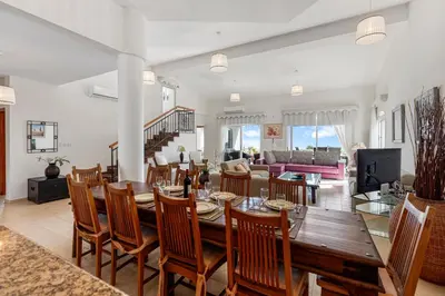 a dining room and living room with a table and chairs at Villa Thea, Luxury Cliff Sea View in Pissouri