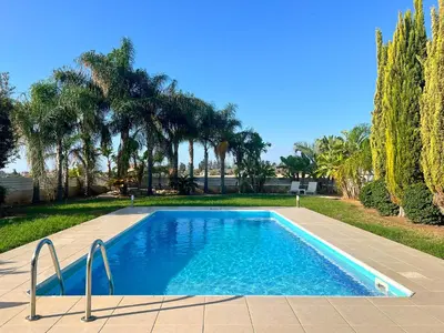 a swimming pool in a yard with trees at Villa Aris in Ayios Theodhoros
