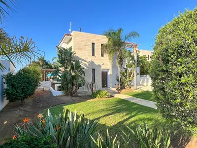 a house with a yard with trees and grass at Villa Aris in Ayios Theodhoros