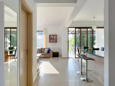a kitchen and living room with a table and chairs at Villa Aris in Ayios Theodhoros