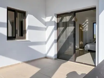 a white wall with sliding glass doors in a room at Villa Aris in Ayios Theodhoros