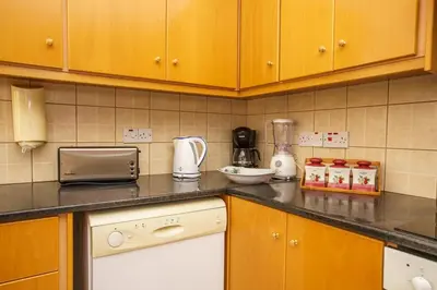 a kitchen with wooden cabinets and a counter top at STAY Villa Kangaroo in Protaras