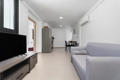 a living room with a couch and a flat screen tv at PANATHEON - Luxury 1 & 2 bdr bungalows 300 meters from sandy beach! in Ayia Napa