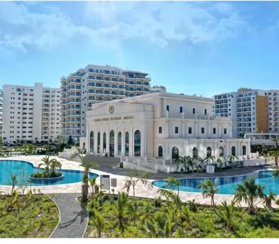 a large white building with palm trees and buildings at Caesar Resort Apartments Marcellus 51 in Iskele
