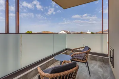 a balcony with two chairs and a table at Pantio Living Residence in Meneou