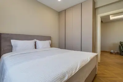 a bedroom with a large bed with white sheets at Pantio Living Residence in Meneou