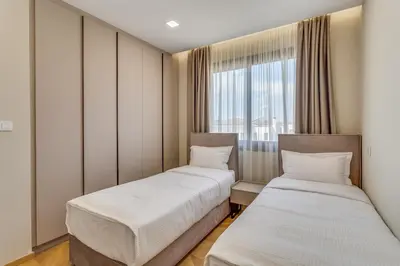 two beds in a room with a window at Pantio Living Residence in Meneou