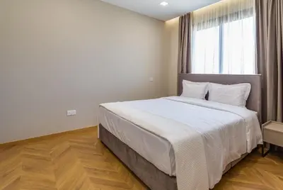 a bedroom with a large bed with a large window at Pantio Living Residence in Meneou