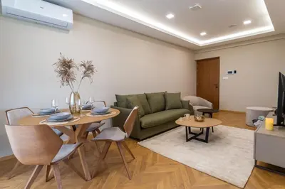 a living room with a couch and a table and chairs at Pantio Living Residence in Meneou