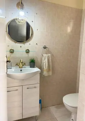 a bathroom with a sink and a toilet and a mirror at Holiday home in Kapparis in Paralimni