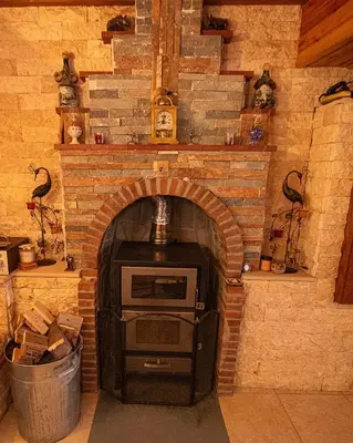a brick fireplace with a stove in a room at Archontikon 1817 in Kaliana