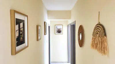 a hallway with paintings and pictures on the walls at Stylish 2BR Apartment with Balcony, Wifi & Pool in Larnaka