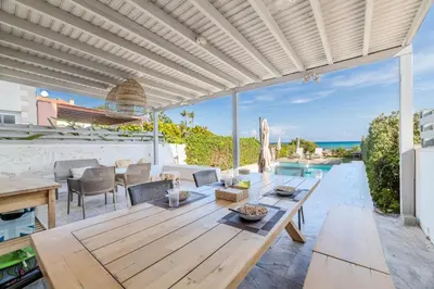an outdoor patio with a wooden table and chairs at Ayia Thekla Beach House in Ayia Napa