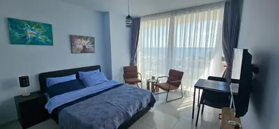 a bedroom with a bed and a desk and a window at Muhteşem Deniz Manzaralı Stüdyo in Iskele
