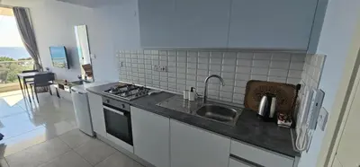 a kitchen with a sink and a stove top oven at Muhteşem Deniz Manzaralı Stüdyo in Iskele