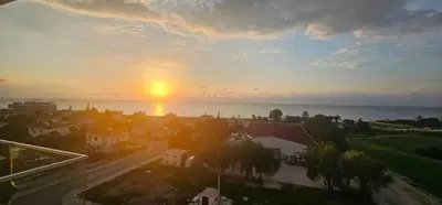 a sunset over a city with the ocean at Muhteşem Deniz Manzaralı Stüdyo in Iskele