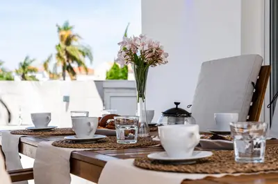 a wooden table with a vase of flowers on it at Casa Giovanni By Ezoria Villas in Ayia Napa