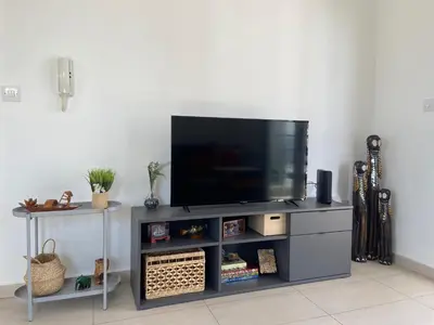a entertainment center with a flat screen tv on top at Cozy Central Stay with City Views in Nicosia