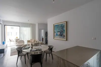 a kitchen and living room with a table and chairs at Kalamon Luxury Suite 203 w Pool and Gym in Livadhia