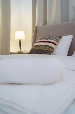 a close up of a bed with a lamp on a table at Kalamon Luxury Suite 203 w Pool and Gym in Livadhia