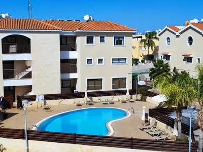 a swimming pool in front of a building at Anemone - walk to the beach in Paralimni