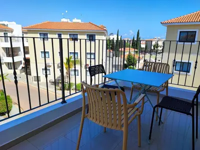 a balcony with a table and chairs and a view of a building at Anemone - walk to the beach in Paralimni