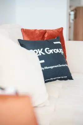 a black pillow sitting on a white couch at Kalamon Luxury Suite 105 w Pool & Gym in Livadhia