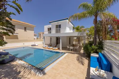 a villa with a swimming pool in front of a house at Protaras Utopia in Protaras