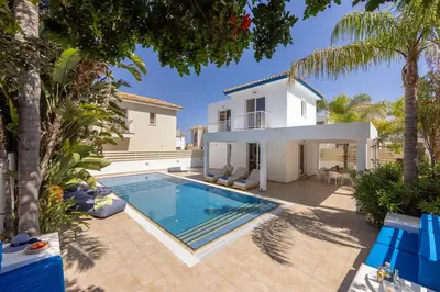 a villa with a swimming pool in front of a house at Protaras Utopia in Protaras