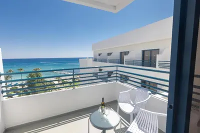 a balcony with a table and chairs and the ocean at Iliada Beach Hotel in Protaras