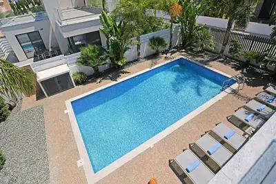 an overhead view of a swimming pool with chairs and a building at Villa Evergreen - 3bed Bungalow large pool in Protaras