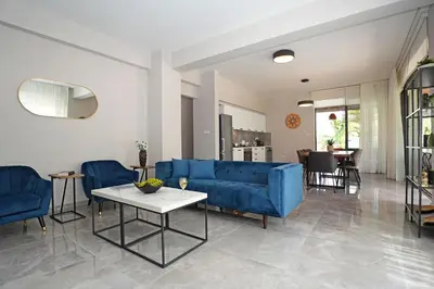 a living room with a blue couch and a table at Villa Evergreen - 3bed Bungalow large pool in Protaras