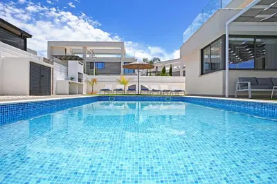 a large swimming pool in front of a house at Villa Violeta - 3bed Bungalow large pool in Protaras