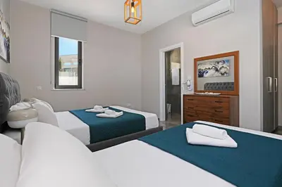 a hotel room with two beds and a bathroom at Villa Violeta - 3bed Bungalow large pool in Protaras