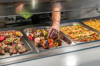 a chef preparing food in a restaurant kitchen at Papantonia Hotel in Protaras