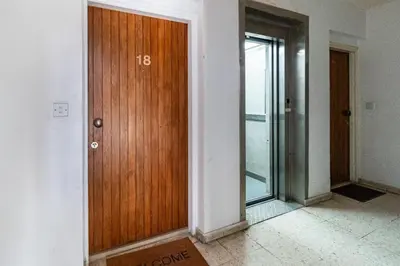 a wooden door in a room with a window at Aeolis Court Apartment by Ezoria Villas in Limassol