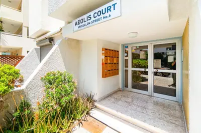 a door to a building with a sign that reads melville court at Aeolis Court Apartment by Ezoria Villas in Limassol
