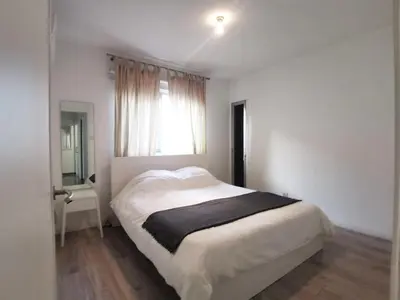 a white bedroom with a bed and a window at Naxou Modern Residence By Staycom in Nicosia