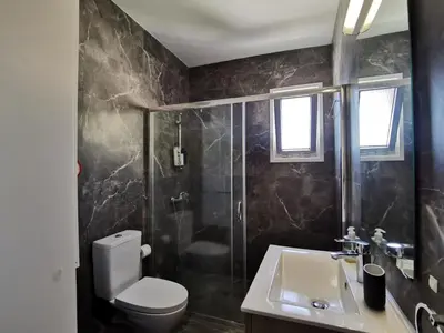 a bathroom with a toilet and a shower and a sink at Naxou Modern Residence By Staycom in Nicosia