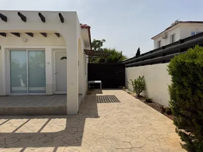 a house with a white door and a patio at Sunset Villa Agia Thekla in Ayia Napa