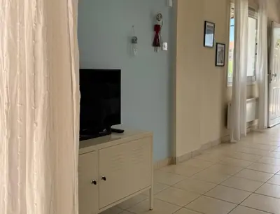a living room with a television on a dresser at Sunset Villa Agia Thekla in Ayia Napa