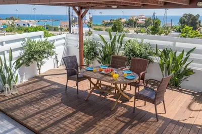 a patio with a table and chairs on a balcony at Narcissos Bay View Villa in Protaras