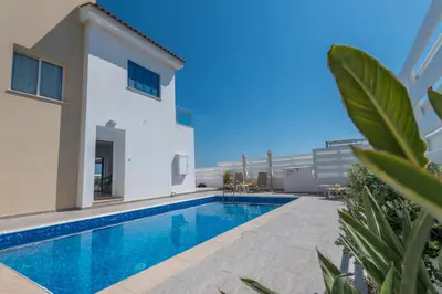 a swimming pool in the backyard of a house at Narcissos Bay View Villa in Protaras
