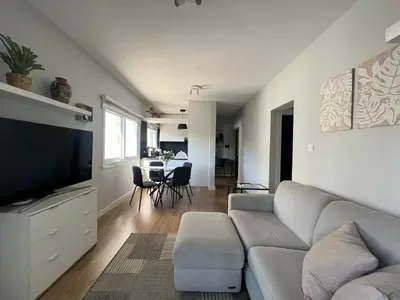 a living room with a couch and a flat screen tv at Cozy City Nest, Heart of Limassol in Limassol