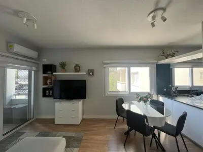 a living room with a table and chairs and a kitchen at Cozy City Nest, Heart of Limassol in Limassol
