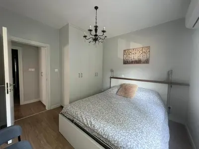 a bedroom with a bed and a chandelier at Cozy City Nest, Heart of Limassol in Limassol