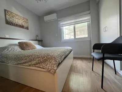 a bedroom with a bed and a chair in it at Cozy City Nest, Heart of Limassol in Limassol