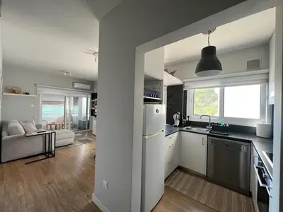 a kitchen and living room with a sink and a refrigerator at Cozy City Nest, Heart of Limassol in Limassol